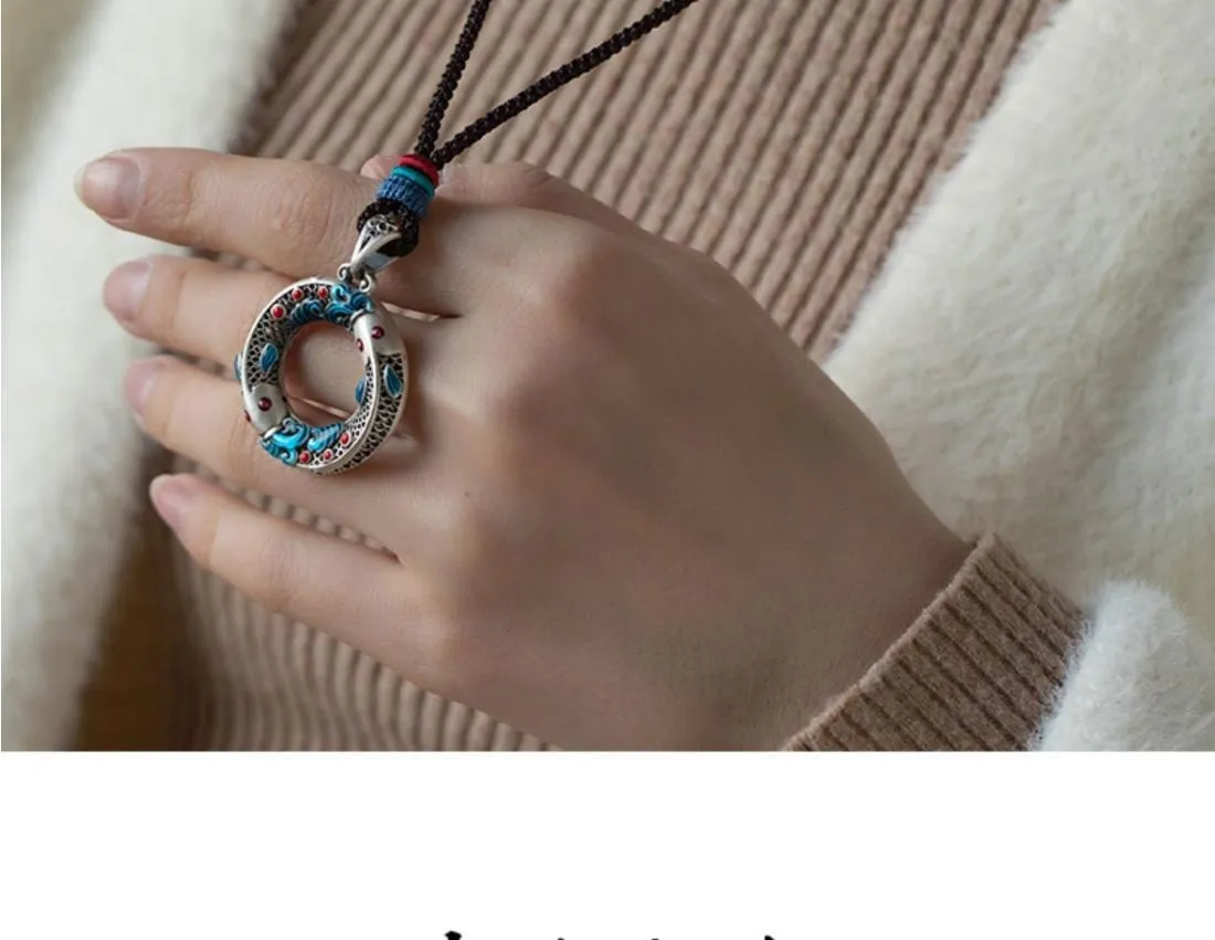 Close-up of hand-painted enamel detail on copper pendant by persimmona