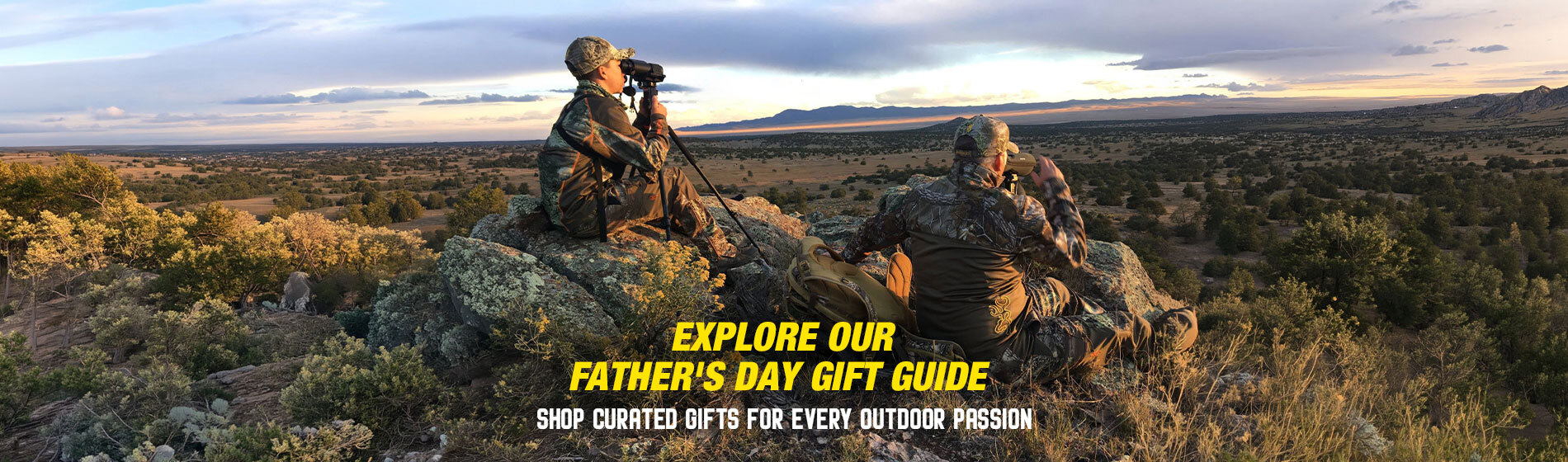 Graphic, man and child in camouflage outdoor gear sitting on rocky hilltop at sunrise using binoculars while overlooking vast landscape of trees and distant mountains, text, Explore Our Father’s Day Gift Guide & Shop Curated Gifts for Every Outdoor Passion 