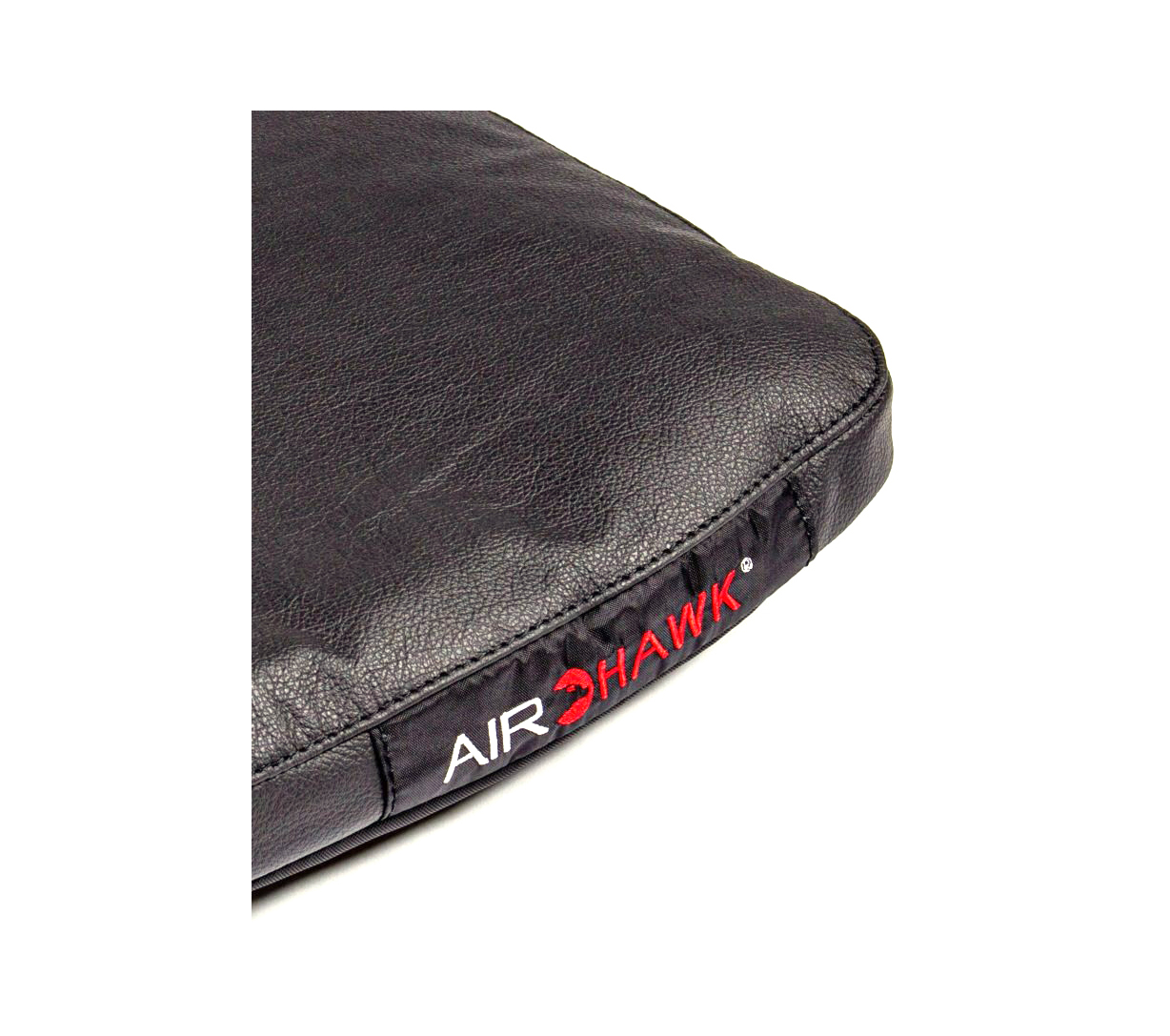 A close-up of the corner of a black leather seat cushion with the words 'AIR HAWK' on it