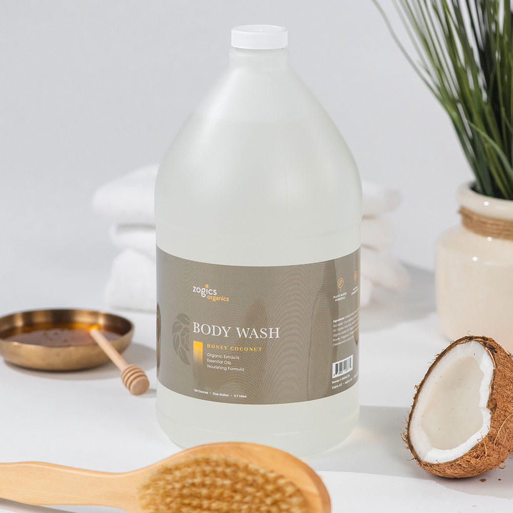 Zogics Honey Coconut Body Wash bottle styled with coconut halves and honey dipper