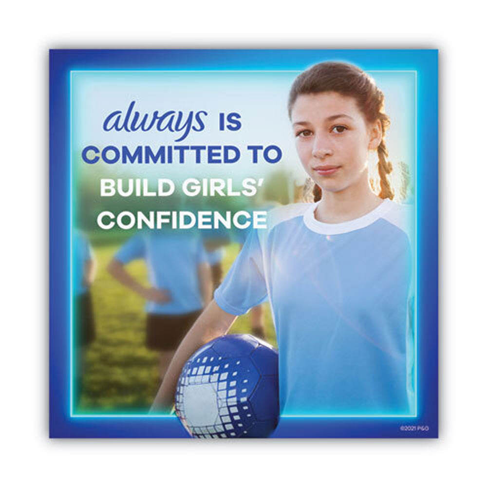 Smiling woman holding a feminine hygiene product in an outdoor setting.