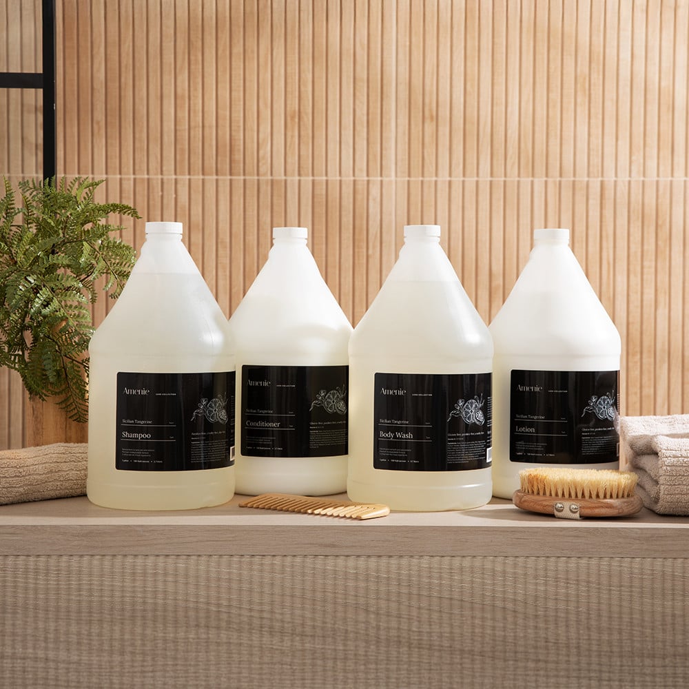 Amenie Sicilian Tangerine full product lineup displayed on a wooden surface, including shampoo, conditioner, body wash, and lotion