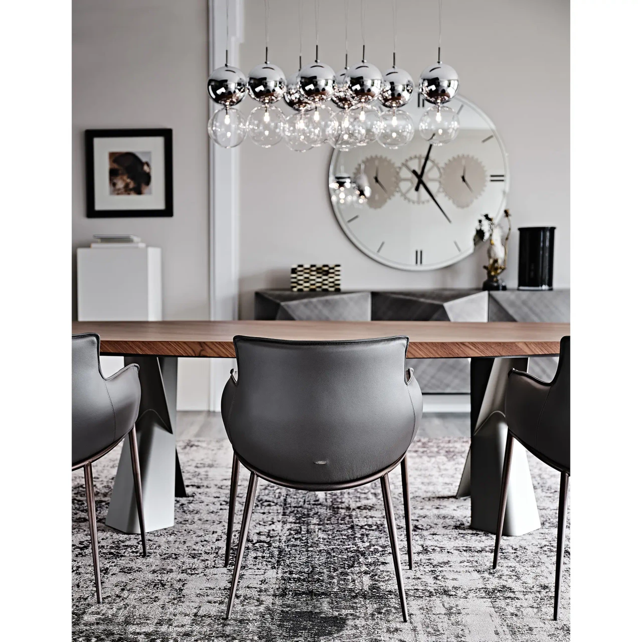 SMOKE || GRAPHITE EMBOSSED STEEL - Modern dining set with a wooden table and black leather chairs on a grey rug, rear view in a contemporary room.