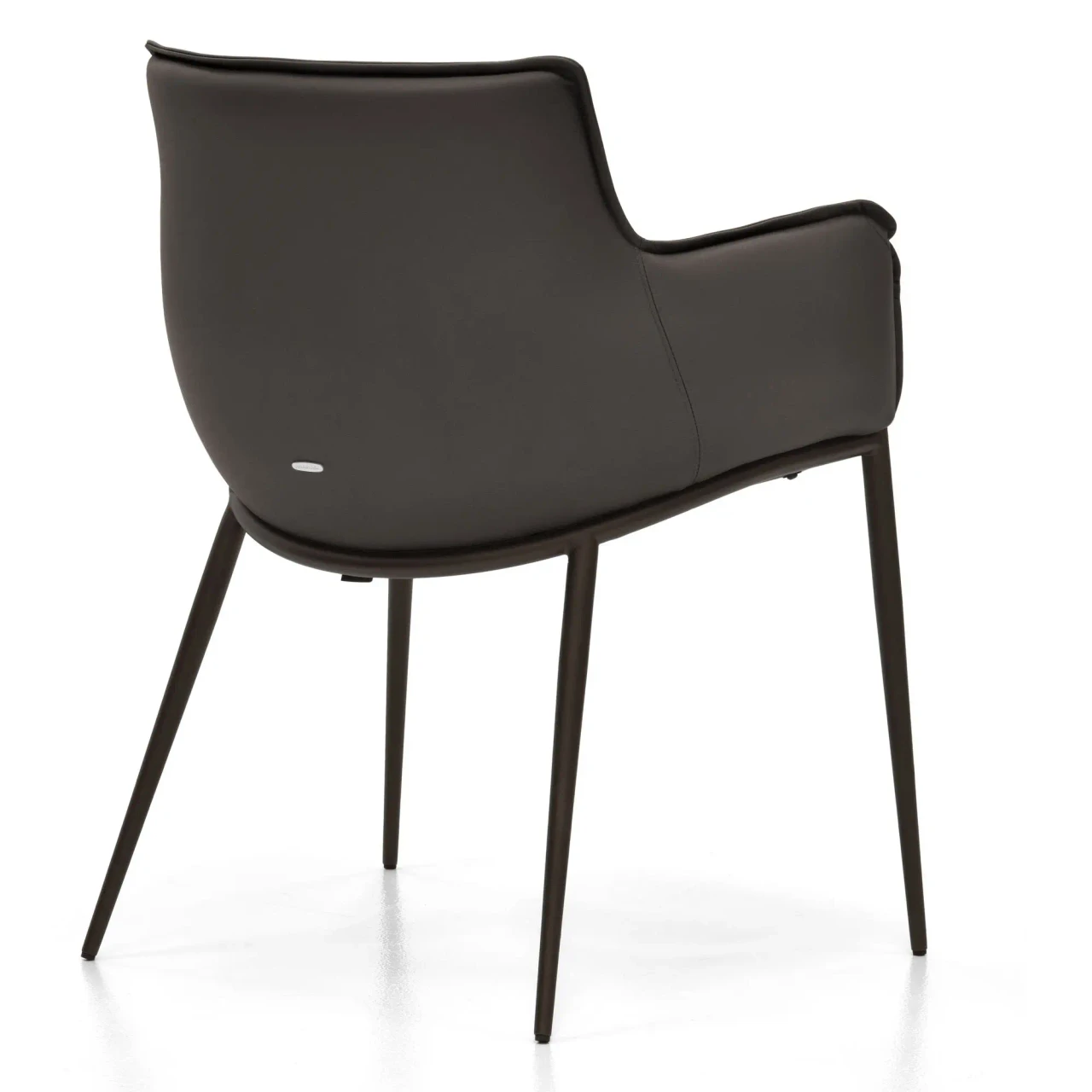 ARDESIA || BRONZE EMBOSSED STEEL - Rear view of a modern dark brown leather armchair with slim black metal legs and a curved silhouette.