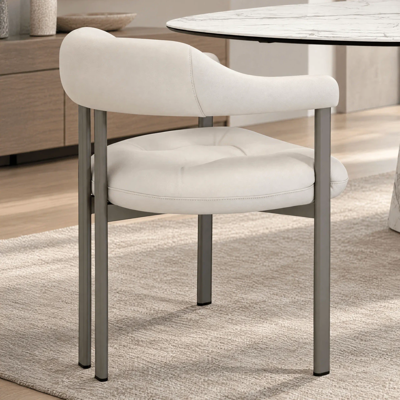Cattelan Greta Arm Chair in Canova soft leather with titanium embossed steel frame, side view in dining room setting.