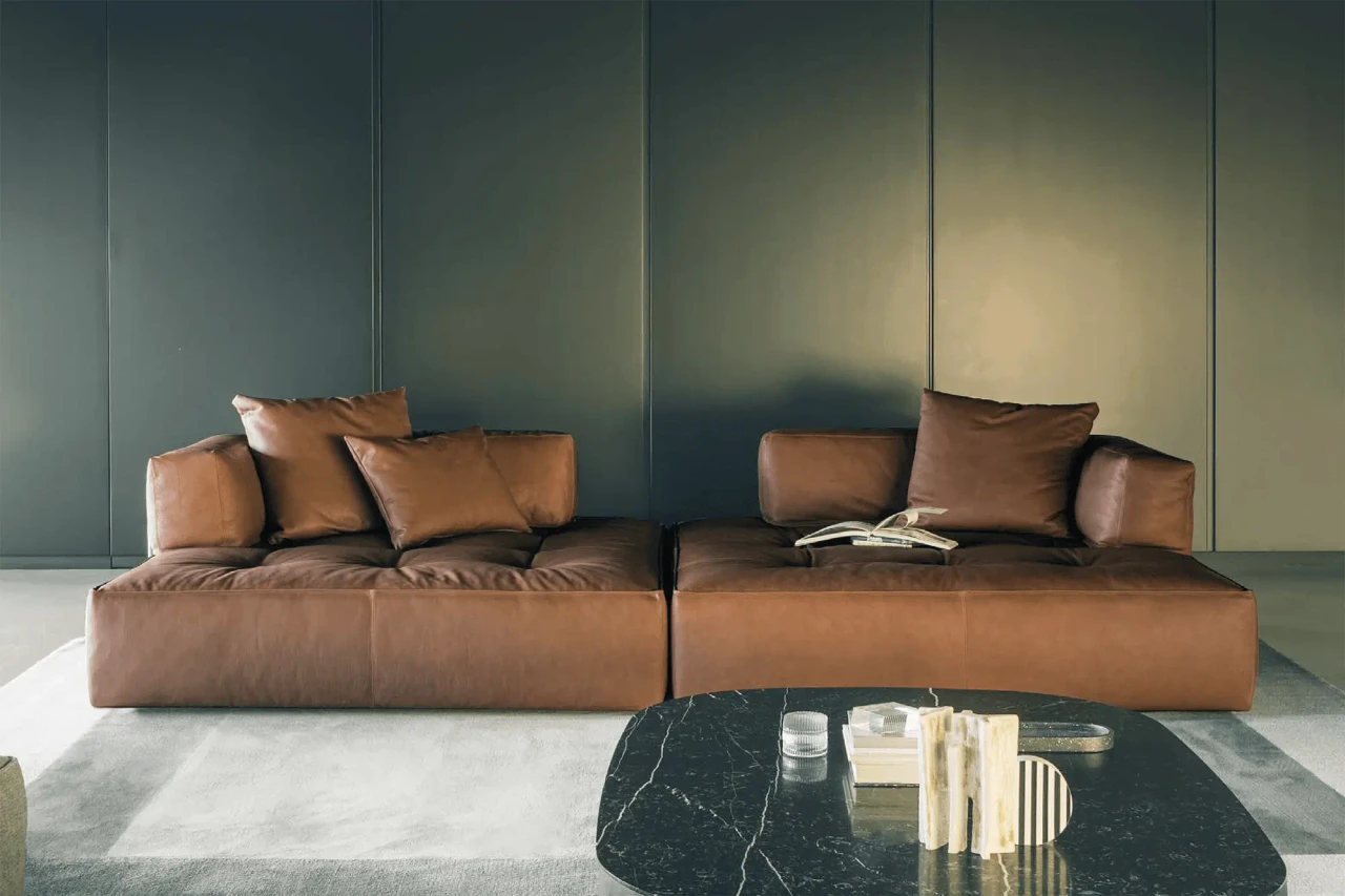 Brown leather modular sectional sofa with cushions, modern style, front view, paired with black marble coffee table.