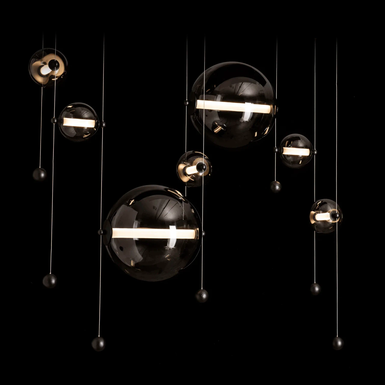 Abacus 7-light Chandelier, modern black finish, cool grey glass spheres, LED lights, front view on black background.