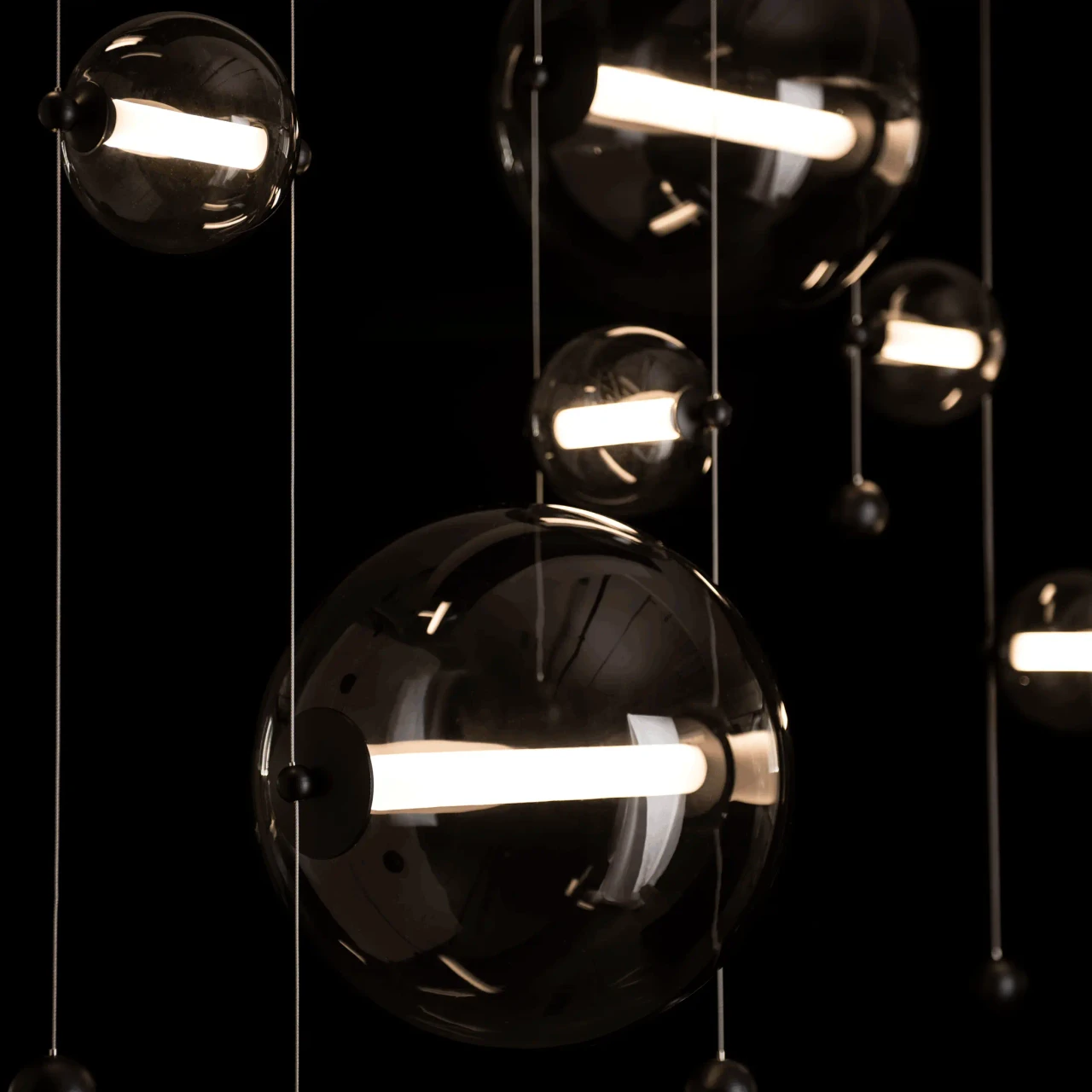 Abacus 7-light Chandelier, modern black finish, cool grey glass spheres with LED lights, close-up detail angle.