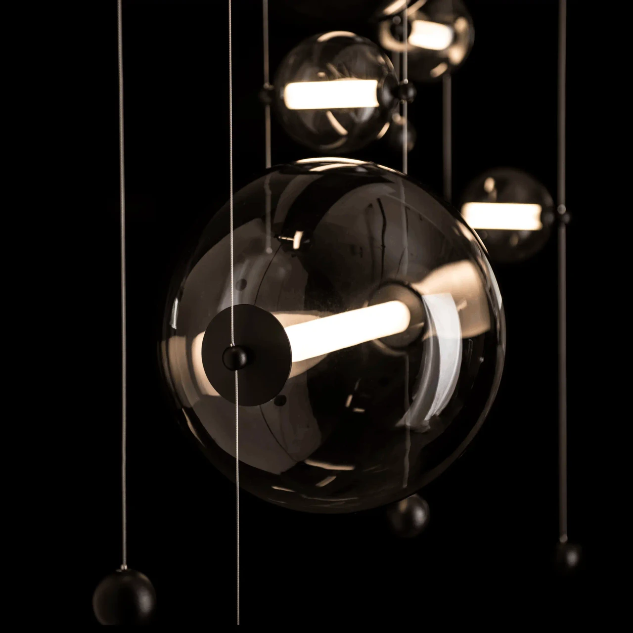 Abacus 7-light Chandelier, modern black finish, cool grey glass spheres with LED bulbs, close-up detail angle.