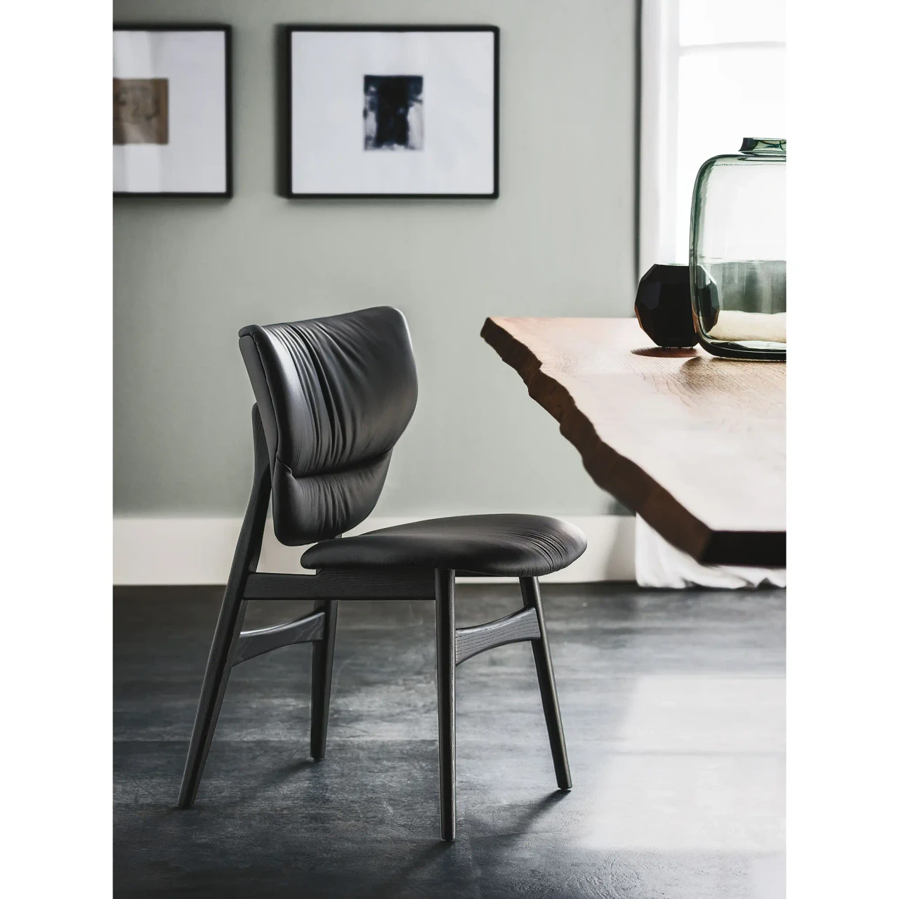 NERO SOFT LEATHER - Cattelan Dumbo Side Chair in Nero/Black Soft Leather and Black Stained Ashwood Frame, side view in a dining room setting.