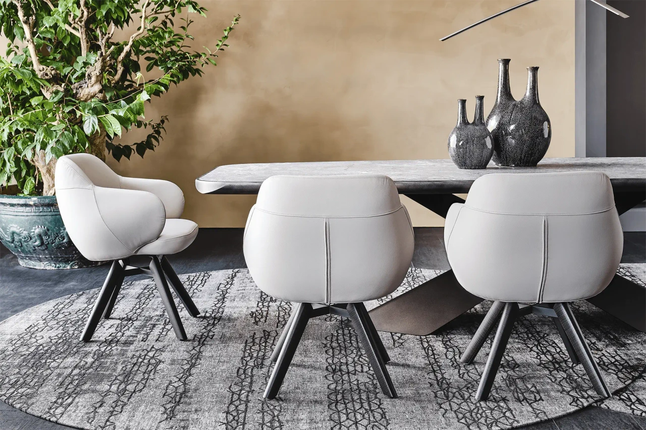 Cattelan Bombe Swivel Chairs in Lino Soft Leather with Burned Oak Legs in a modern dining room, rear three-quarter view.