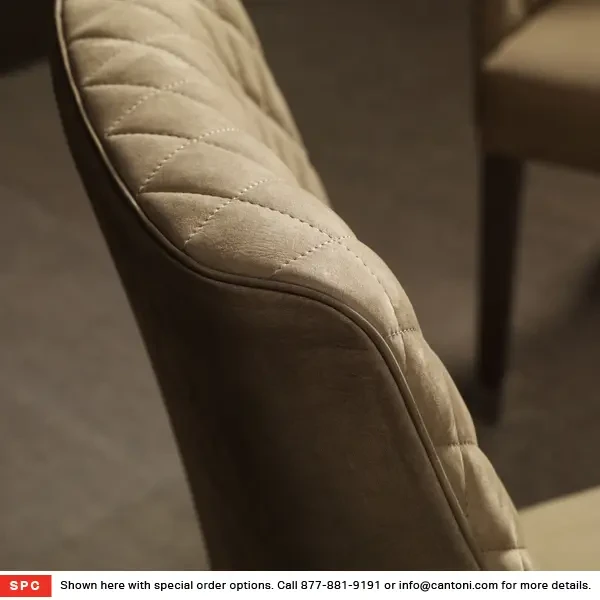 Closeup - Malerba Red Carpet Side Chair, diamond tufted back in ecru leather, close-up angle in dining room setting.