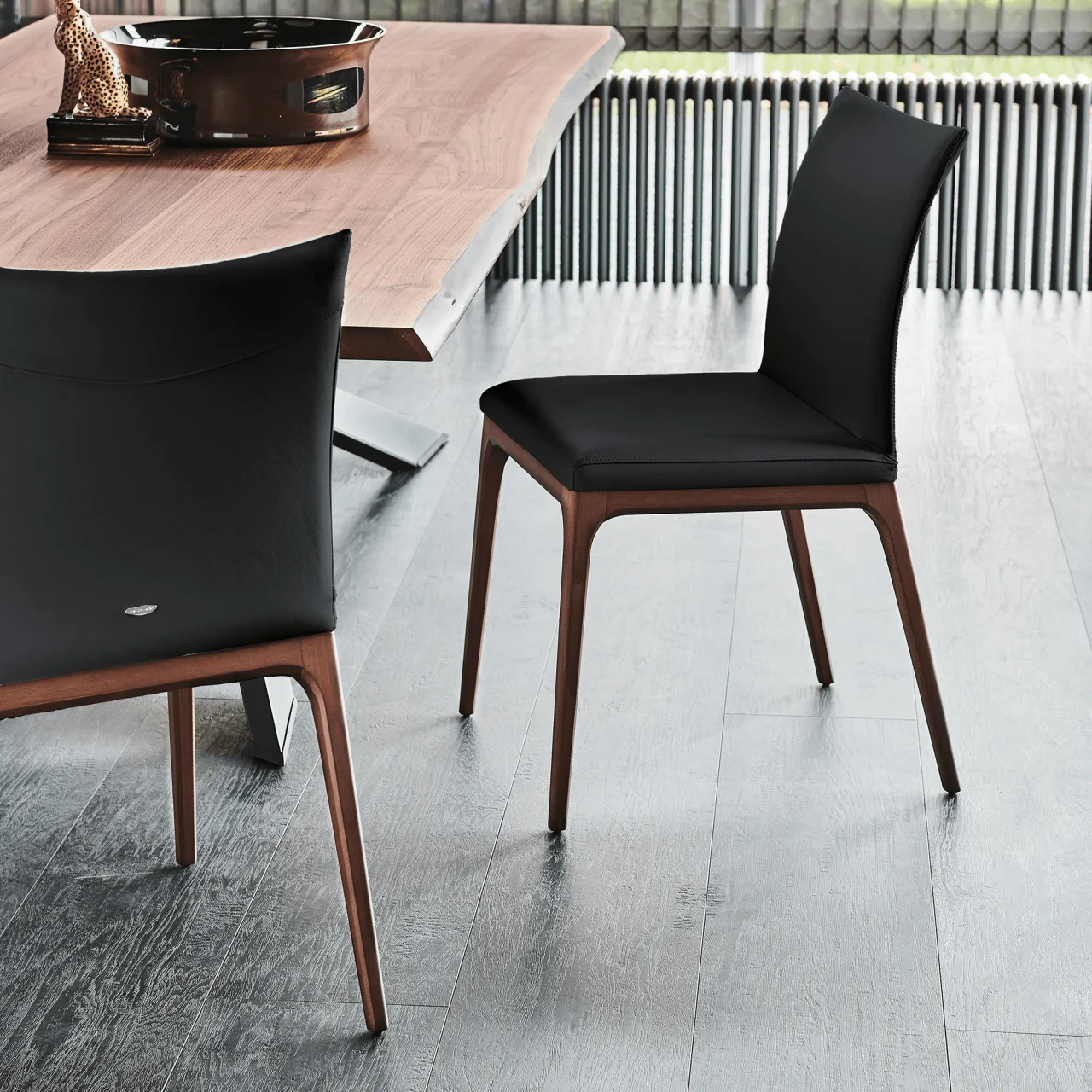 NERO - Cattelan Arcadia Side Chair in Nero Soft Leather with Walnut Stained Beech Frame, dining room setting, side angle view.