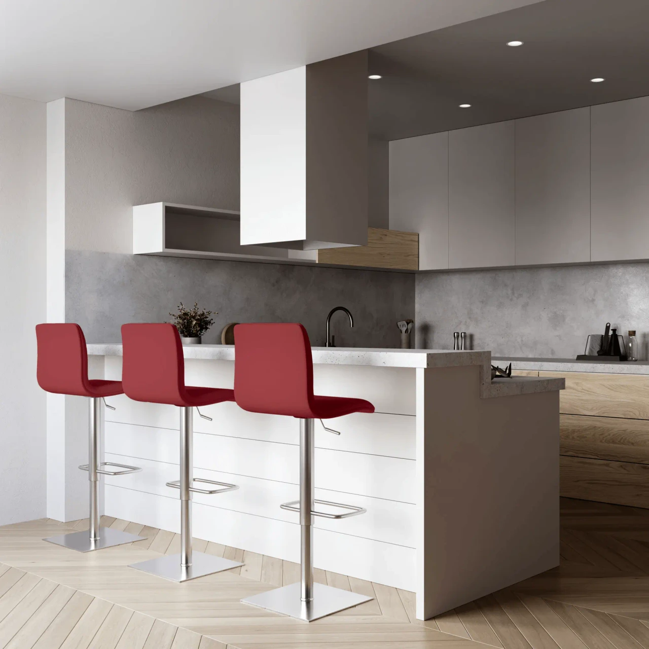 RED LEATHER - Three red modern bar stools with chrome metal bases and footrests at a white kitchen island, front view.