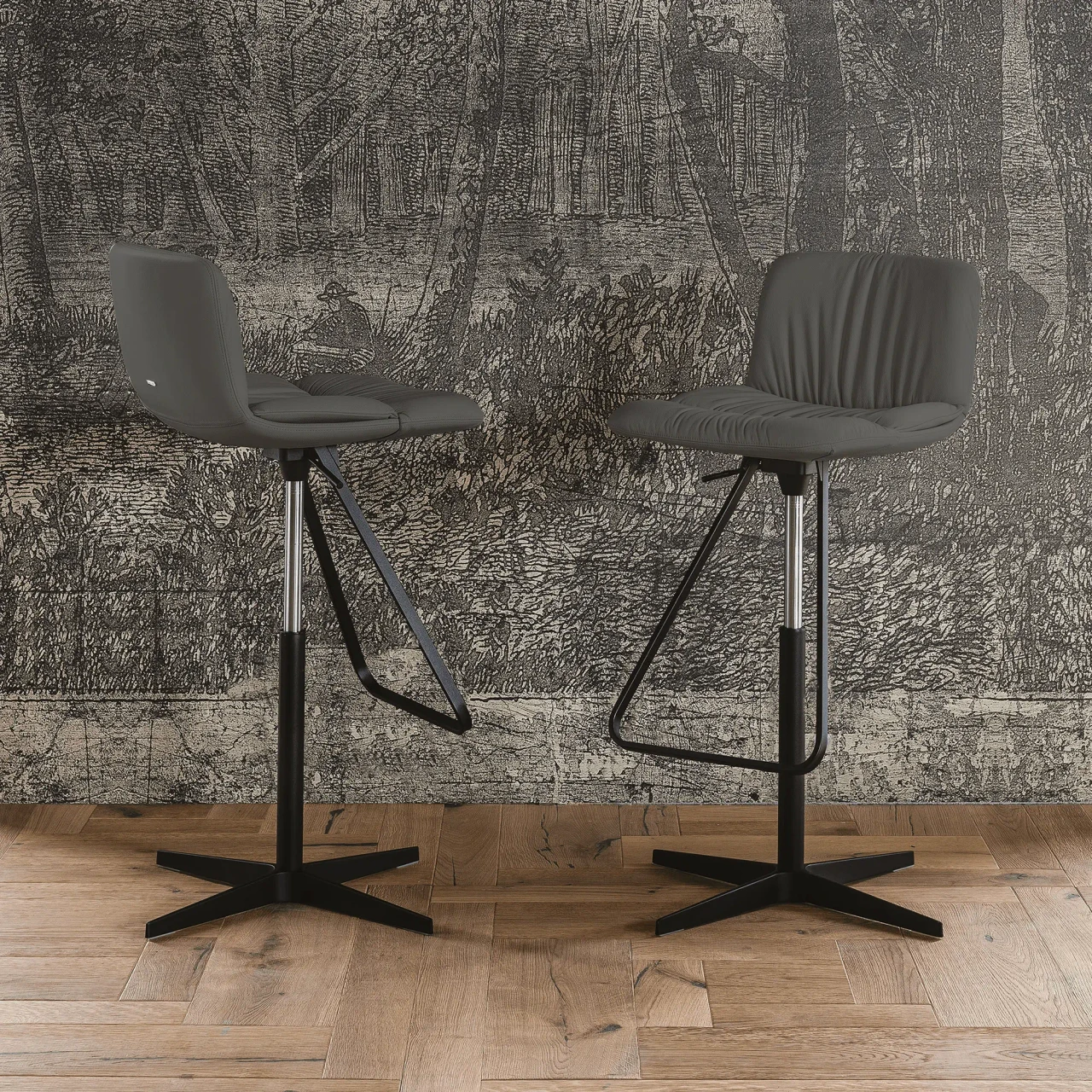 SMOKE - Two Cattelan Axel X Bar Stools in Smoke Soft Leather with Black Spoke Base, Column & Foot, front view in a lifestyle setting.