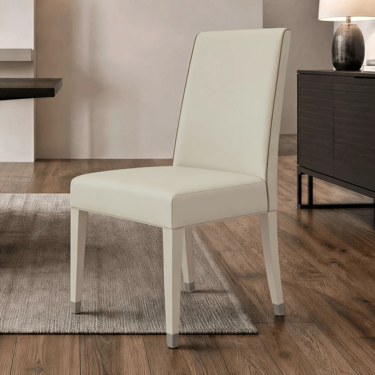 Malerba Perfect Time Side Chair in beige leather with piping and black chrome leg caps, 3/4 view in dining room setting.