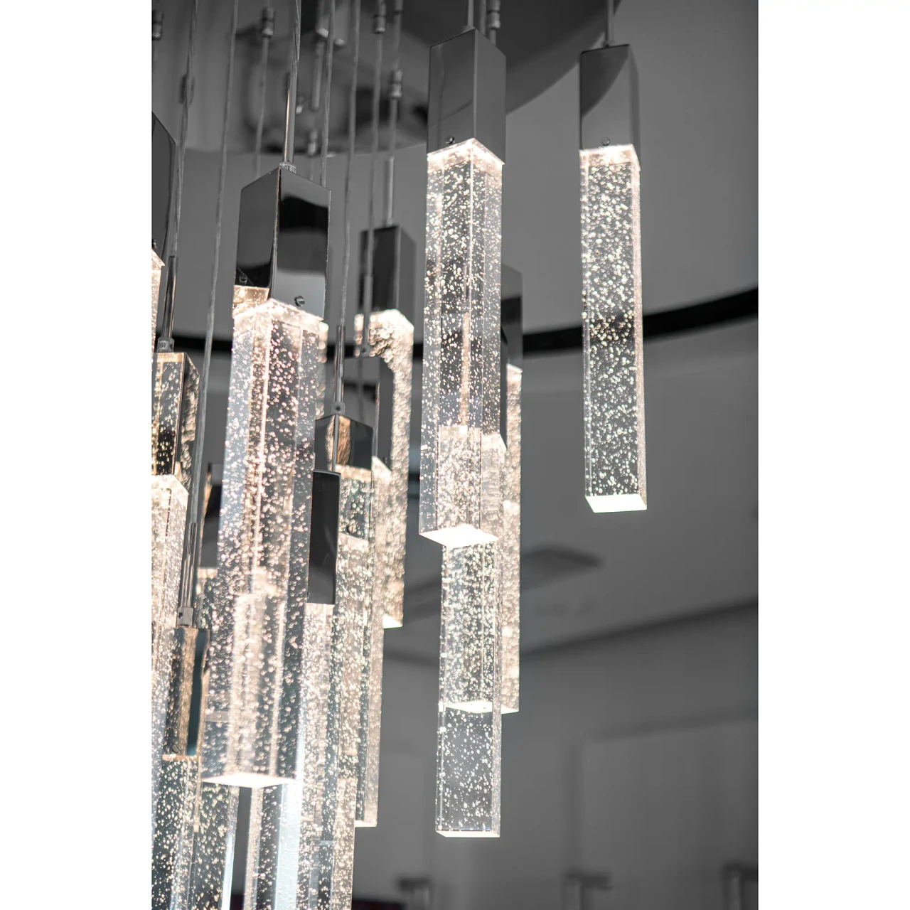 25 || Closeup - Close-up of Glacier Suspension Fixture in polished chrome and bubbled glass with LED bulbs, modern style.