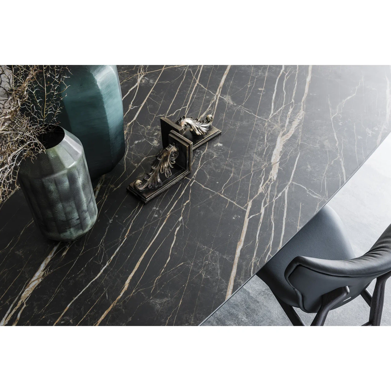 GLOSSY SAHARA NOIR || BRONZE EMBOSSED STEEL - Cattelan Skorpio Keramik Dining Table, Glossy Sahara Noir Ceramic Top, modern style, close-up angle in dining room setting.