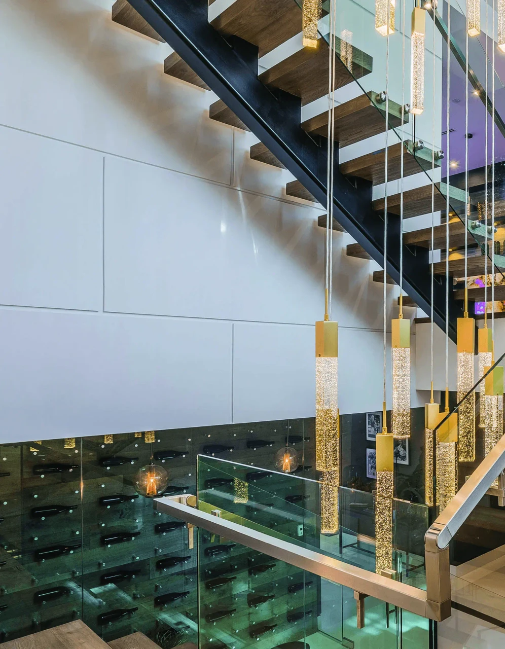 Glacier Suspension Fixture in Brushed Brass and Bubbled Glass, modern style, hanging in a living area, low angle view.