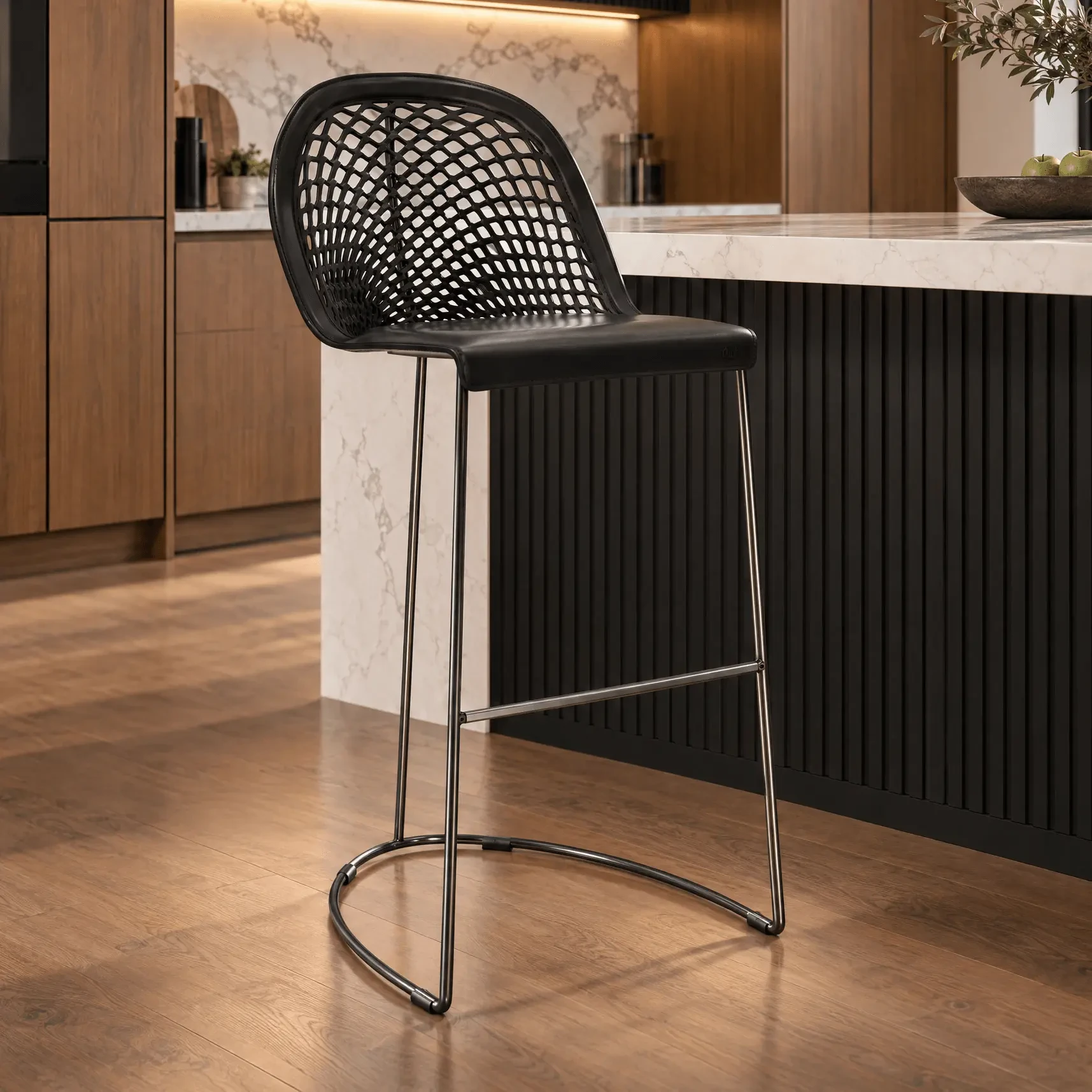 Guapa Bar Stool, modern style, black hide leather and black nickel metal frame, woven back, 3/4 view in kitchen setting.