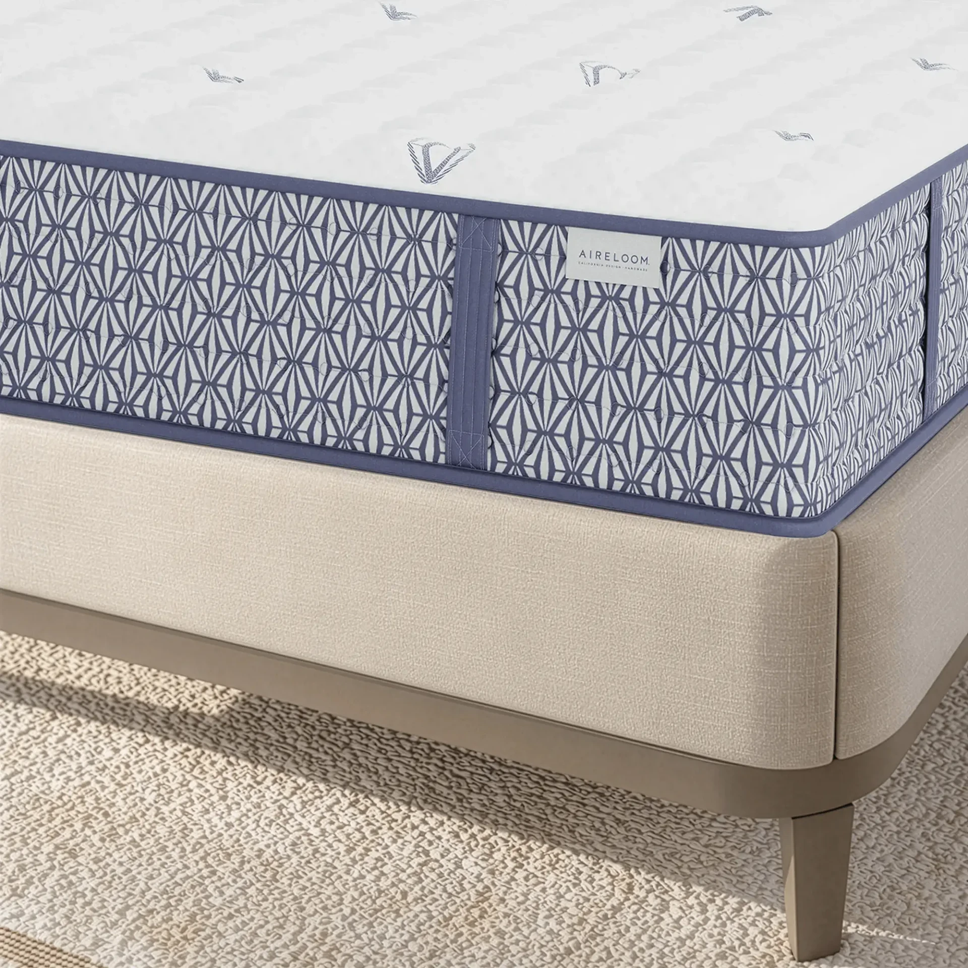 QUEEN - Close-up bedroom view of Aireloom Luxetop Firm M2 Mattress with blue patterned side and beige base on a metal frame.