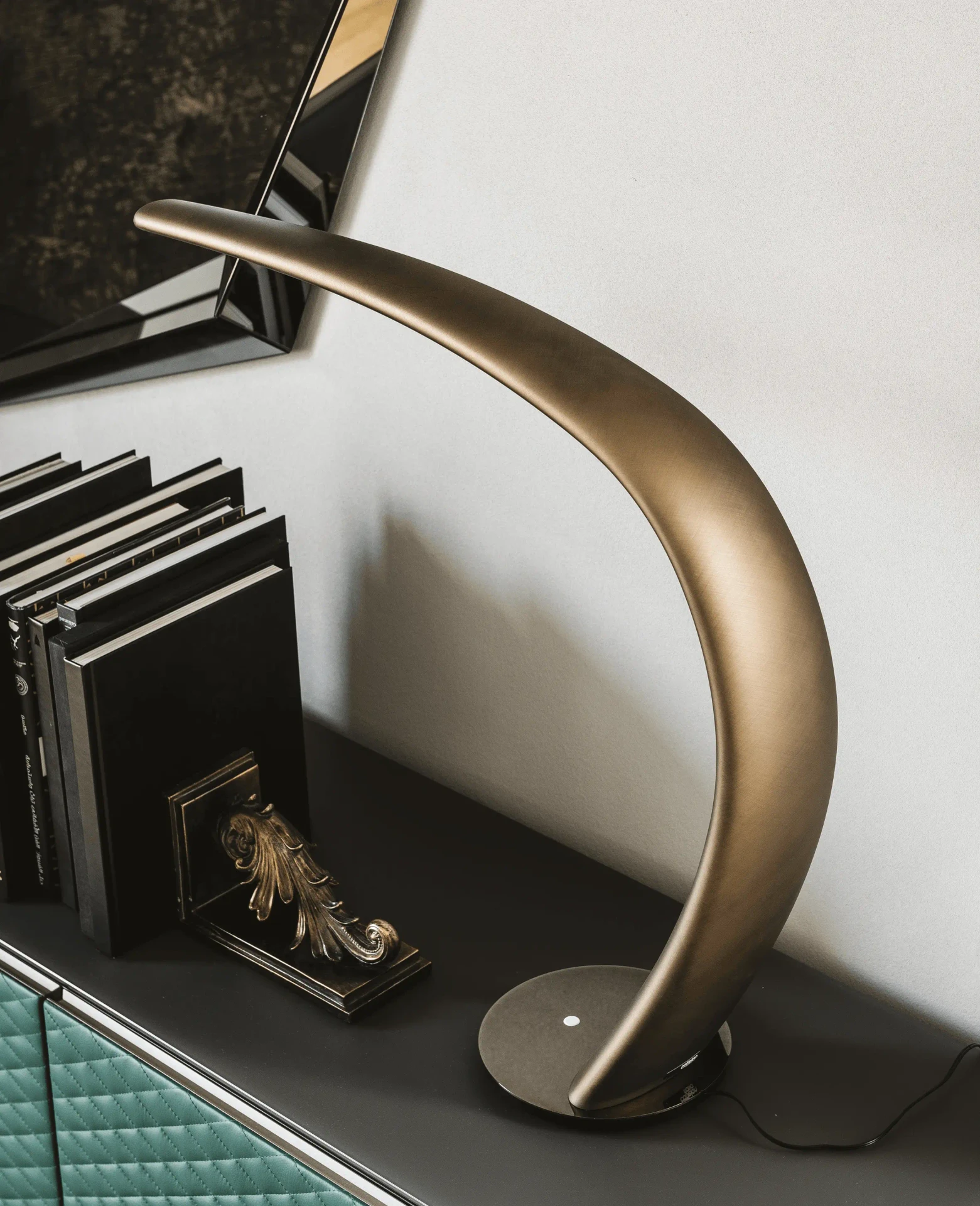 Cattelan Mamba Table Lamp in brushed bronze polyurethane with black chrome base, curved modern design, living room side view