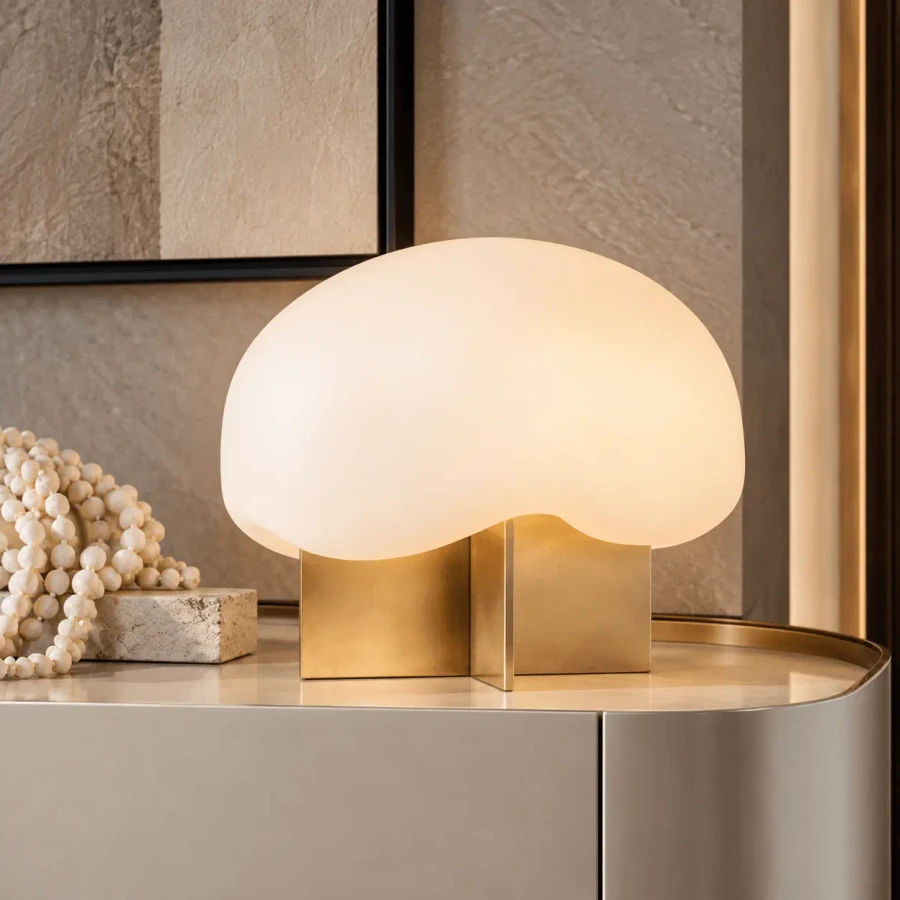 Fio Accent Table Lamp with hand-rubbed antique brass base and clear etched glass shade in a living room, eye-level view.