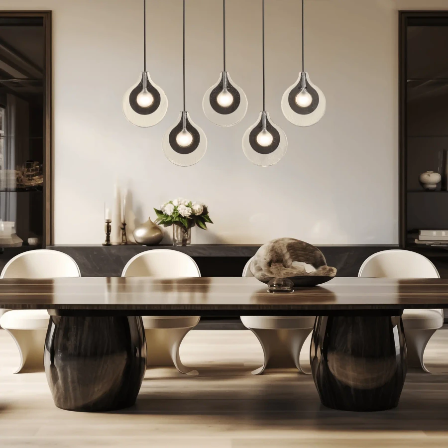 Veneto 5-light linear pendant in oil rubbed bronze and clear frosted glass over a modern dining table, front view.