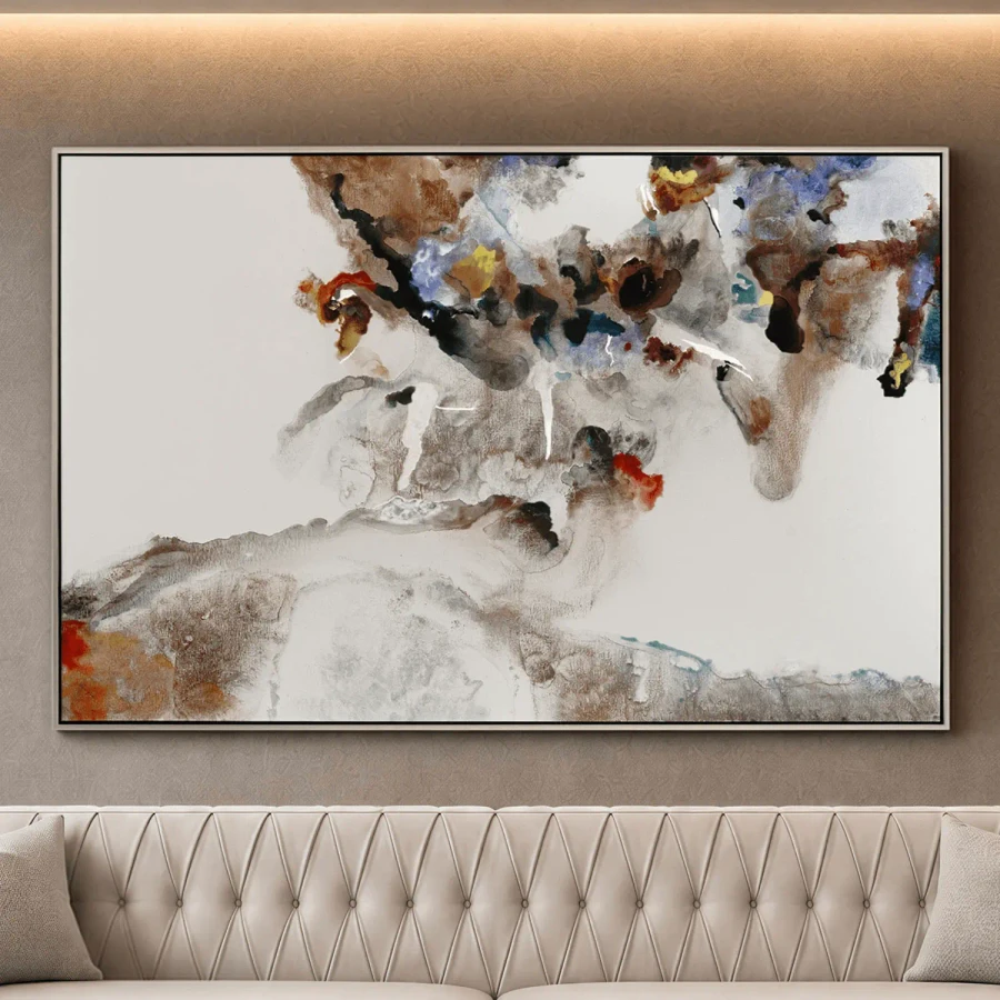 Creation abstract canvas art in silver floater frame, brown and blue tones, front view in living room above tufted sofa.