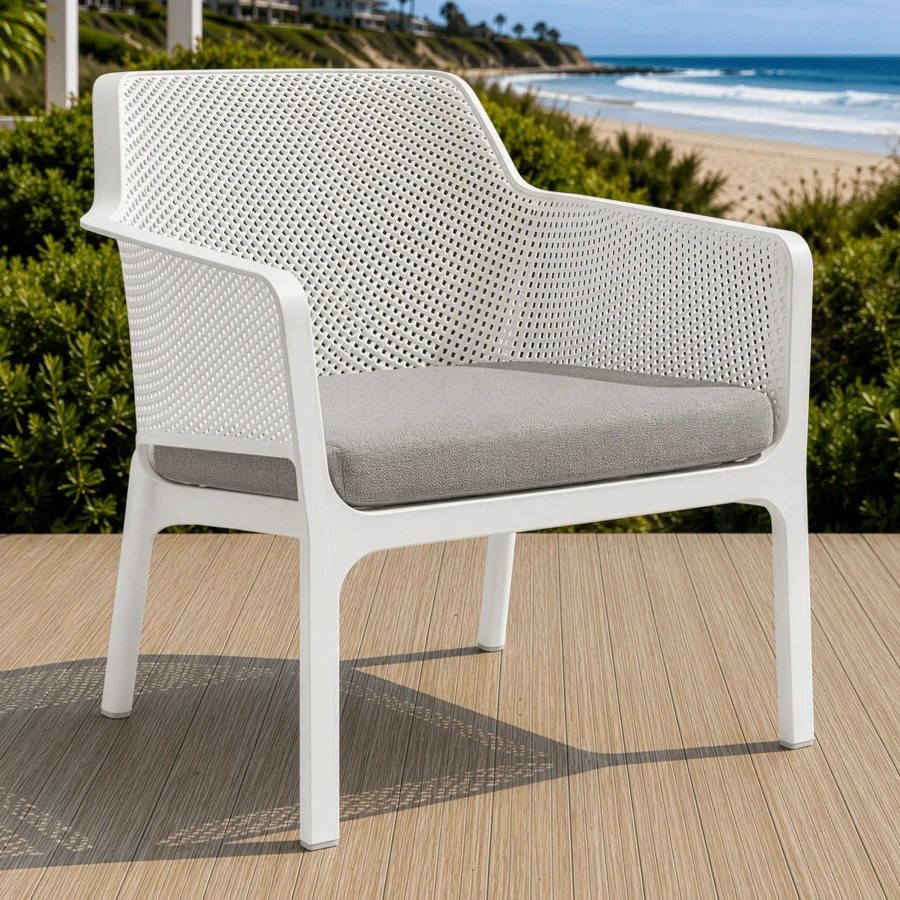 Nardi Net Relax modern outdoor armchair in white polypropylene with grigio Sunbrella cushion, 3/4 view on a wooden deck.