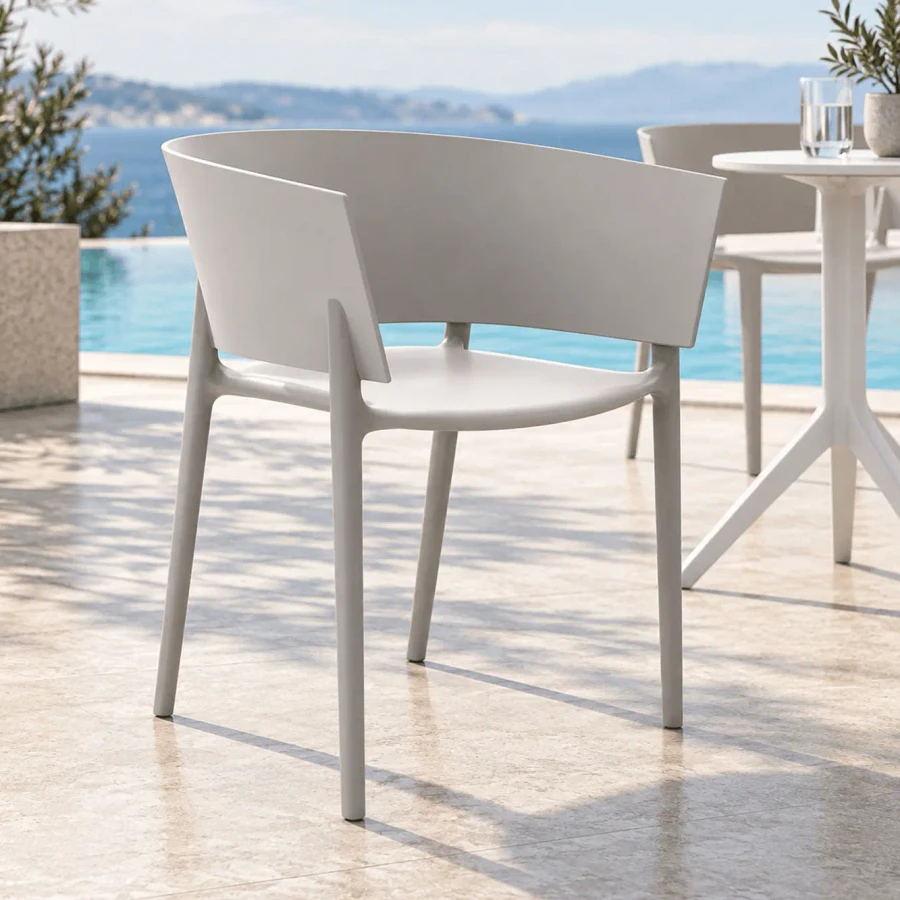 WHITE - Vondom Africa Arm Chair, modern white injection polypropylene outdoor chair, side view on a sunny patio by a pool.
