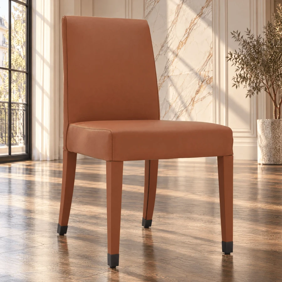Malerba Perfect Time Side Chair in cognac leather with bronze leg caps, side view in a dining room setting.