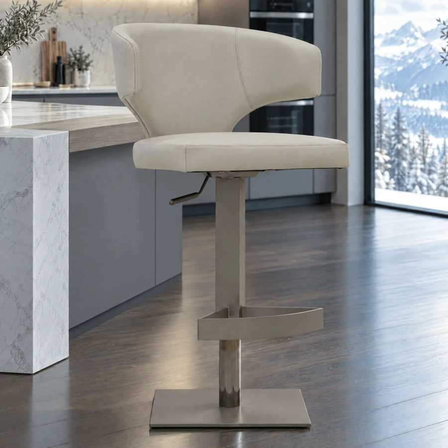 Wing Bar Stool in beige leather with titanium base, post and footrest, side view in a modern kitchen setting.