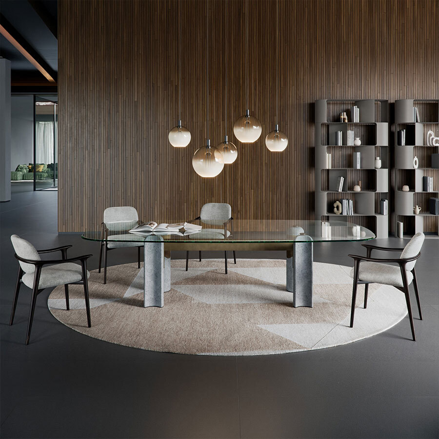 Modern luxury dining room featuring an oval glass-top table with stone pedestal legs, upholstered armchairs, spherical pendant lights, and curved grey bookshelves against a vertical wood slat wall.