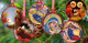 Six Nativity-themed Christmas ornaments with religious scenes hanging from a Christmas tree branch.