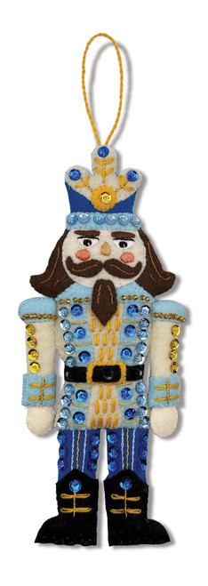Felt nutcracker ornament in blue and gold uniform with mustache, crown, and embroidered accents, holding detailed sequins and beads.