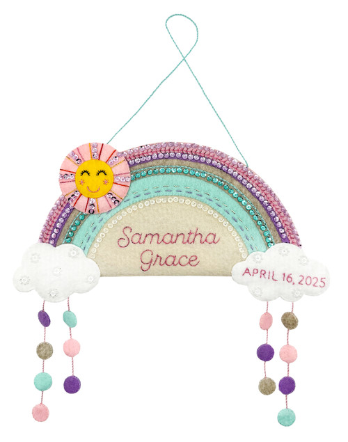 Baby Girl Rainbow TailoredExpressions felt wall hanging with pink and purple rainbow, smiling sun, sequined clouds, and personalized name/date/weight.