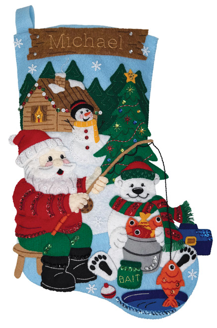 Hooked for the Holidays felt stocking kit featuring Santa and a polar bear ice fishing outside a snowy Christmas cabin. Bucilla