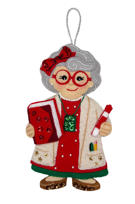 Back to School Mrs. Claus felt ornament kit featuring a teacher-themed Mrs. Claus with red glasses, school notebook, chalk, pencils, sequins and bead embellishments.