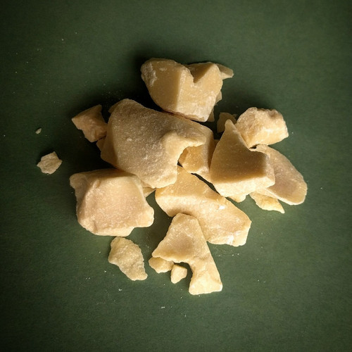 Natural Cocoa Butter chunks over green background