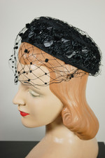 Black fabric and raffia straw mini pillbox hat 1960s with polka dot veil flat crown