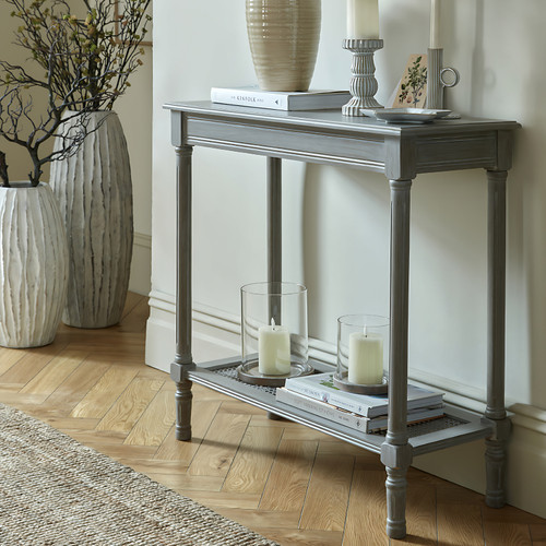 Serene Rattan Console Table styled in a hallway with candles and a ceramic vase