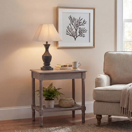 Incia fluted wooden table lamp lit on a side table beside an armchair with framed art