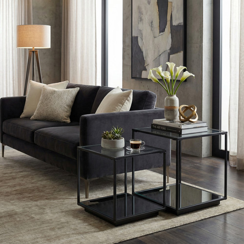 Lennox Black Framed Set Of 2 Side Tables styled beside a dark sofa with flowers and books