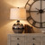 Sepia Shadows Table Lamp styled on a wooden dresser beneath a large statement clock
