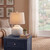 Squat White Beaded Ceramic Lamp with linen shade, lit, styled on a bedside table