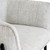 Close-up of the Zephra Chair's textured fabric and armrest curve