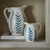 Close-up of two ceramic jug vases styled on a shelf inside the Delphine Sliding Glass Dresser Top