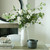 Amalfi Grey Hydria Pot styled with white faux floral arrangement beside a matching ceramic vase