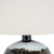 Close-up of Midnight Shadows table lamp showing the glossy black neck fitting and drip-glaze finish beneath the linen shade